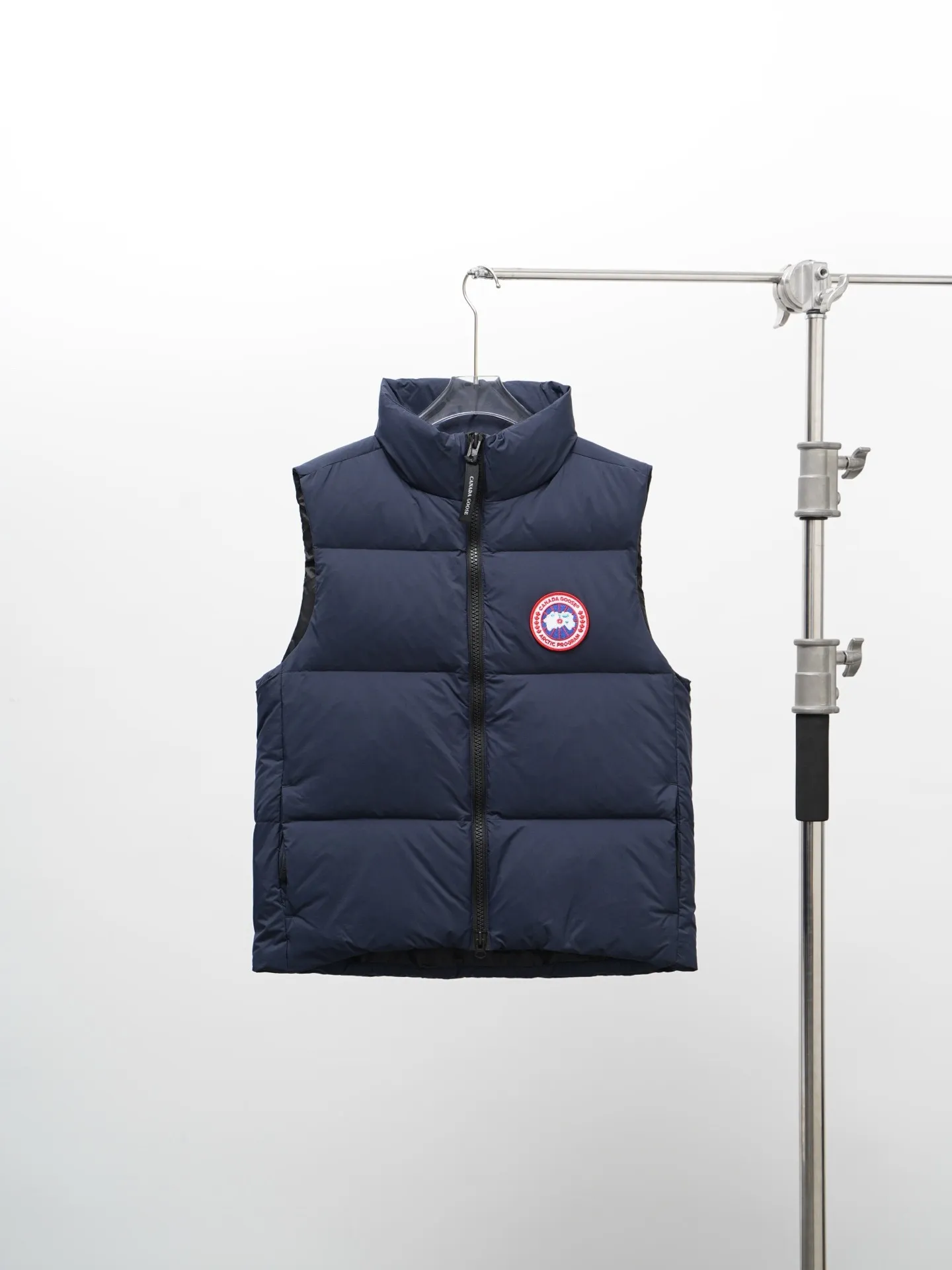 P580 Canada gooes Lawrence Down Vest (high version) With a durable shell and quilted body, the Lawrence Down Vest is a must-have for all seasons. The fabric has a durable soft touch. Longer hem at back for added protection. Reflective double-stripe grip tape at back. The Lawrence features an engineered down-filled collar to block strong winds, a two-way front zip and a longer rear hem. Color: black with red label, black with black label, desert color, ocean blue Size: XS -2XL